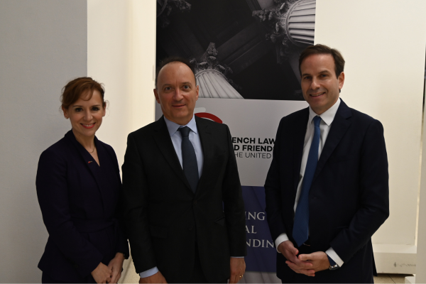 a woman and two men standing in front of abstract art