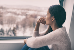 concerned woman looking out window